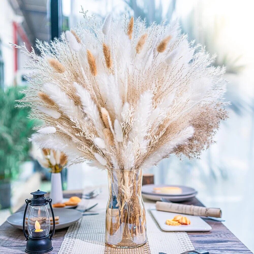 Dried pampas and bunny tail grass bouquet in clear glass vase on dining table centerpiece