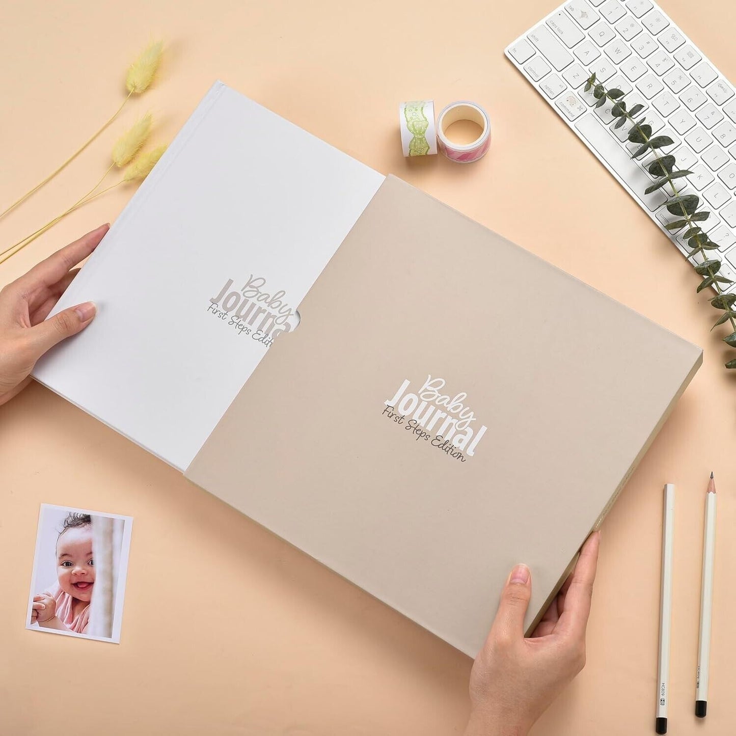 Gateway22 baby journal first steps with beige and white cover held open on desk with keyboard and photo