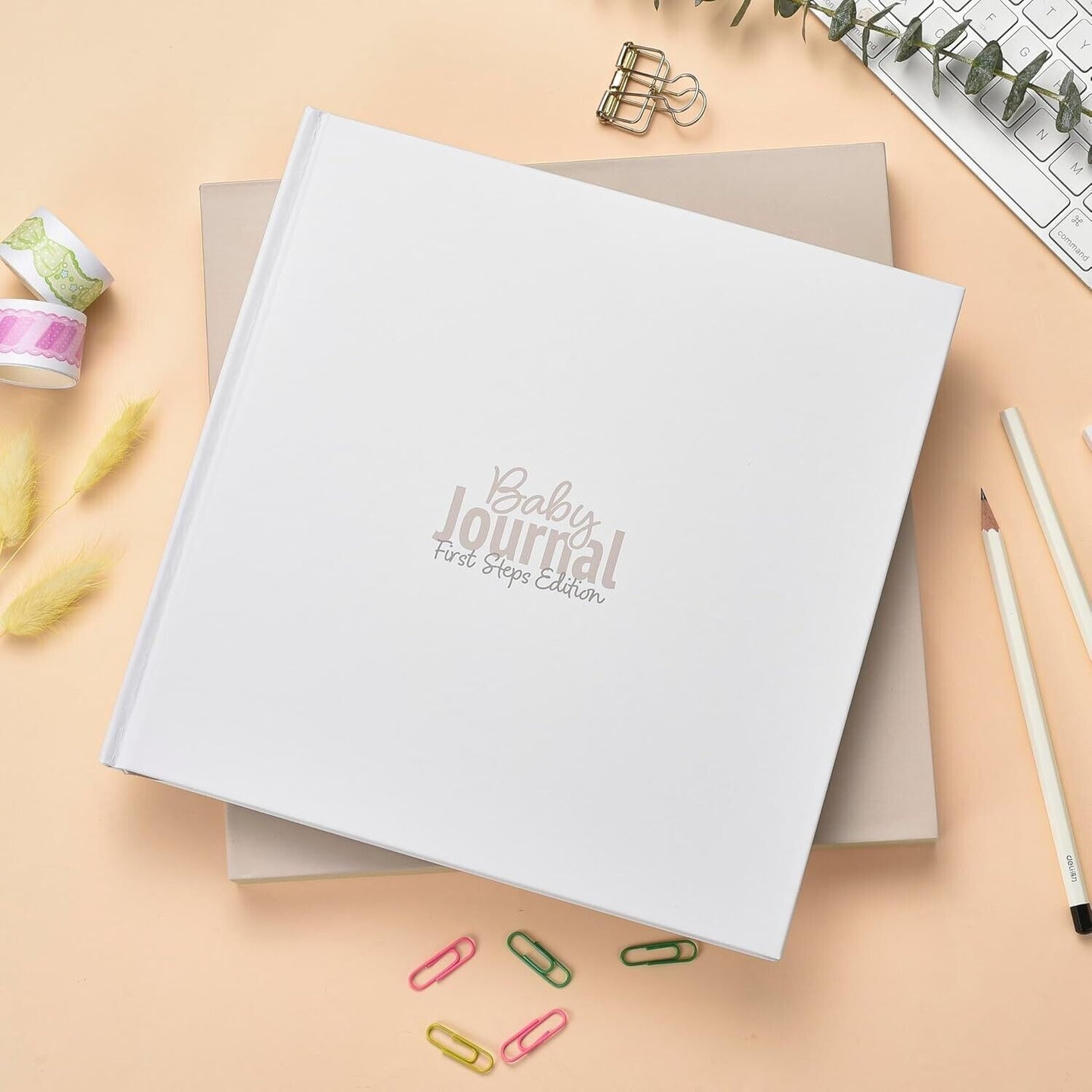 Gateway22 white baby journal first steps book with pencils and paper clips on peach background