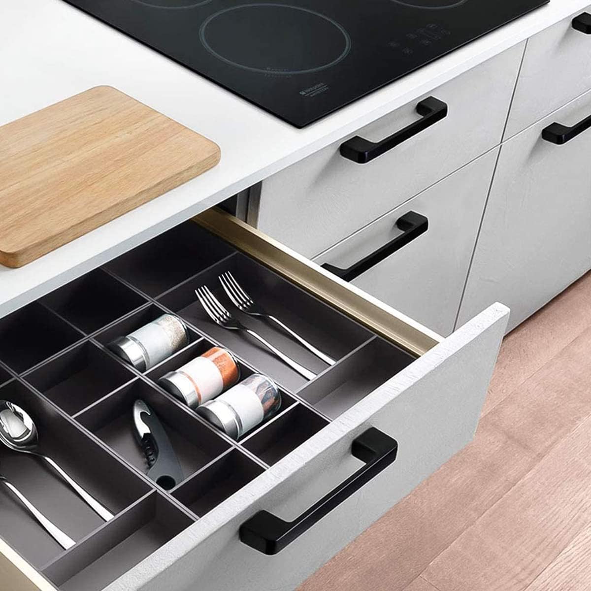 GUWINA black kitchen cabinet handles 96mm on a modern kitchen drawer with organised utensils