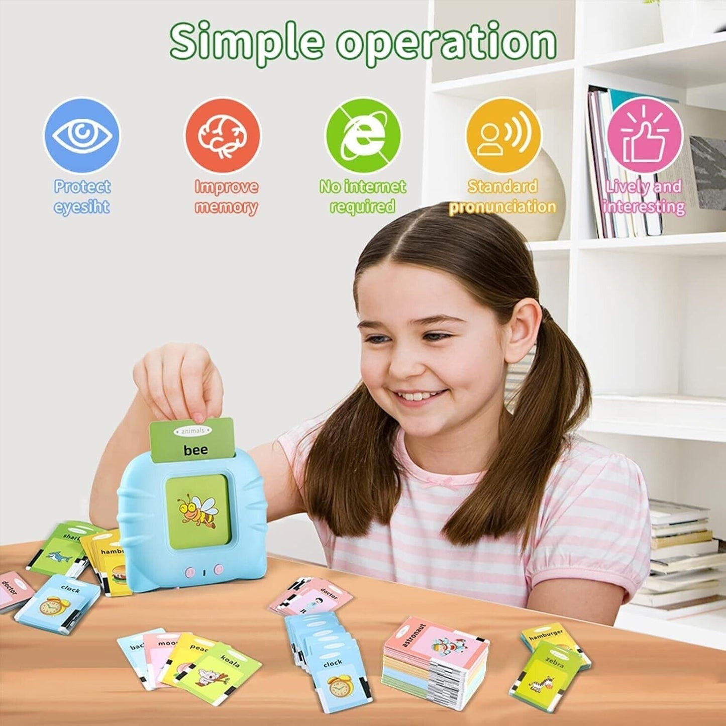 Child smiling while using an early educational voice card toy with flashcards on a table, promoting learning.