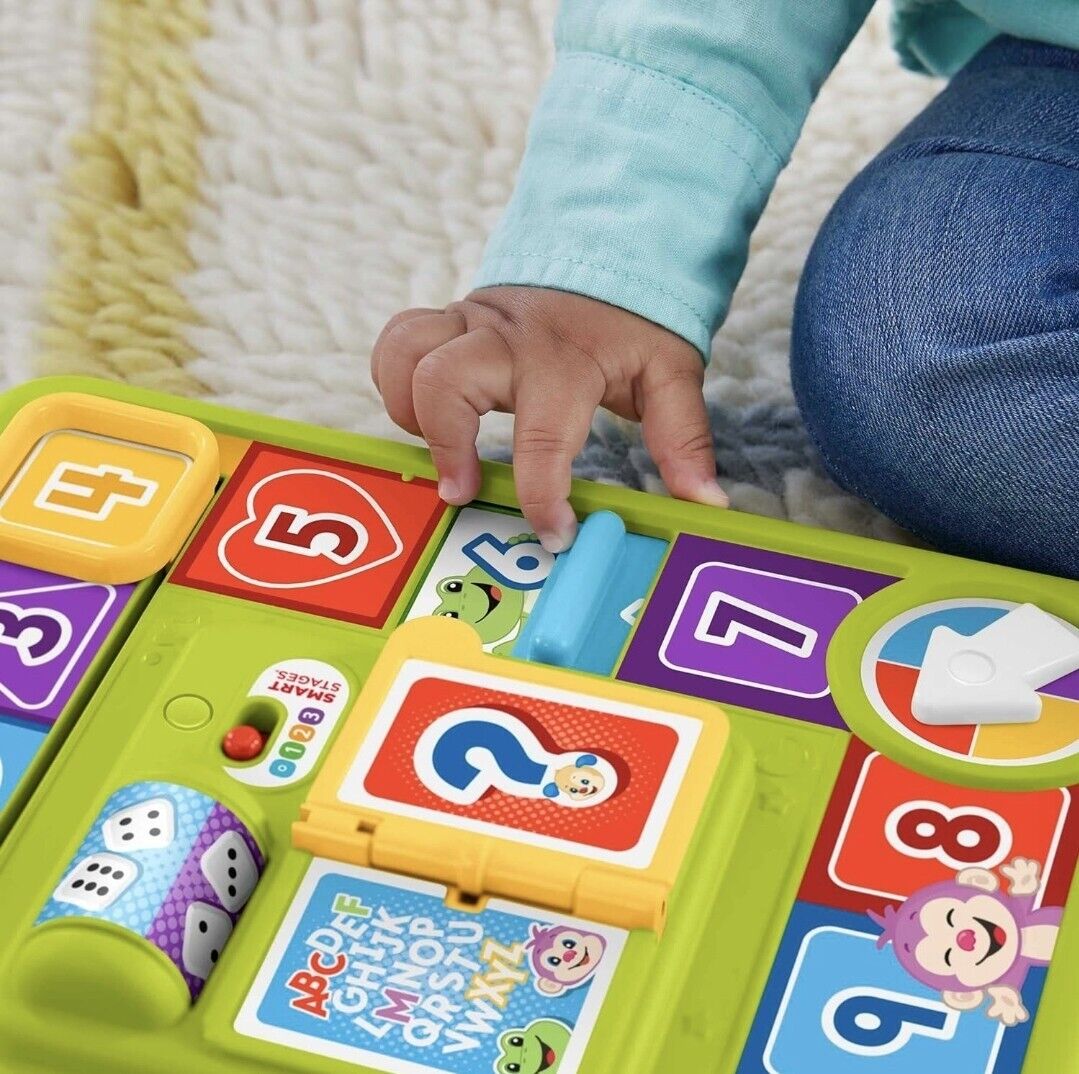 Child exploring the Fisher-Price interactive activity board with colourful letters and shapes