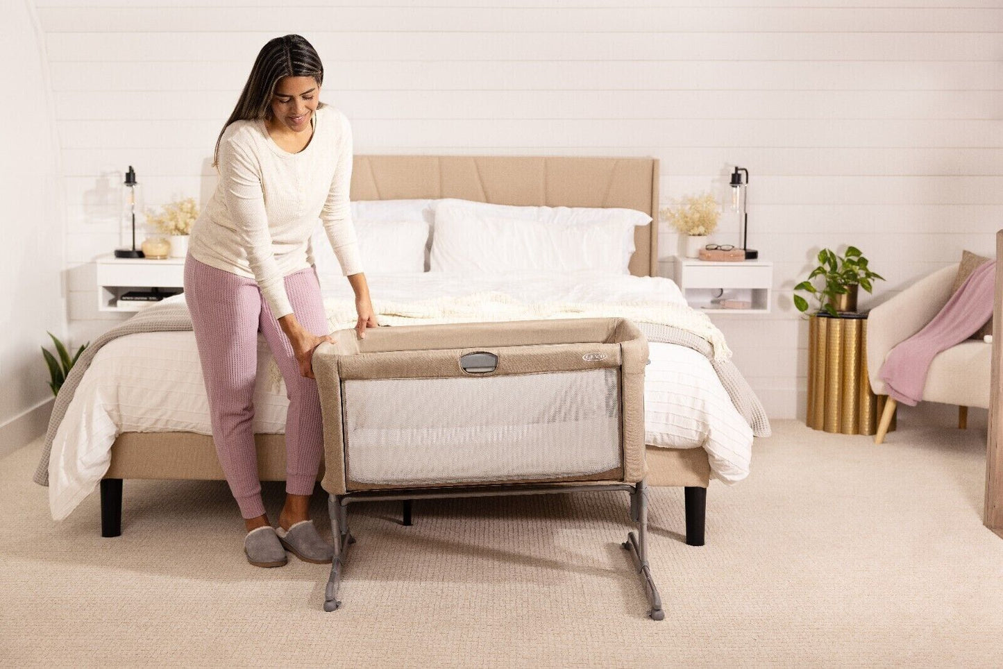 GRACO bedside crib for newborns positioned next to a bed, perfect for easy access during nighttime