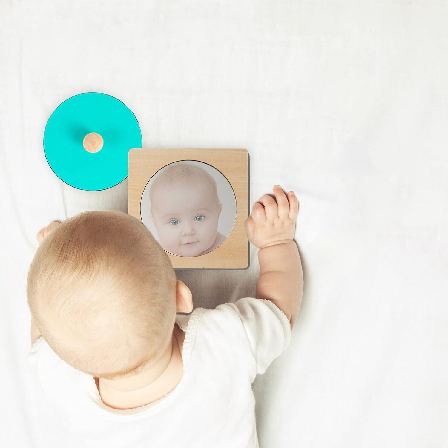Toddler using a Montessori mirror puzzle for toddlers with a wooden base and a circular mirror