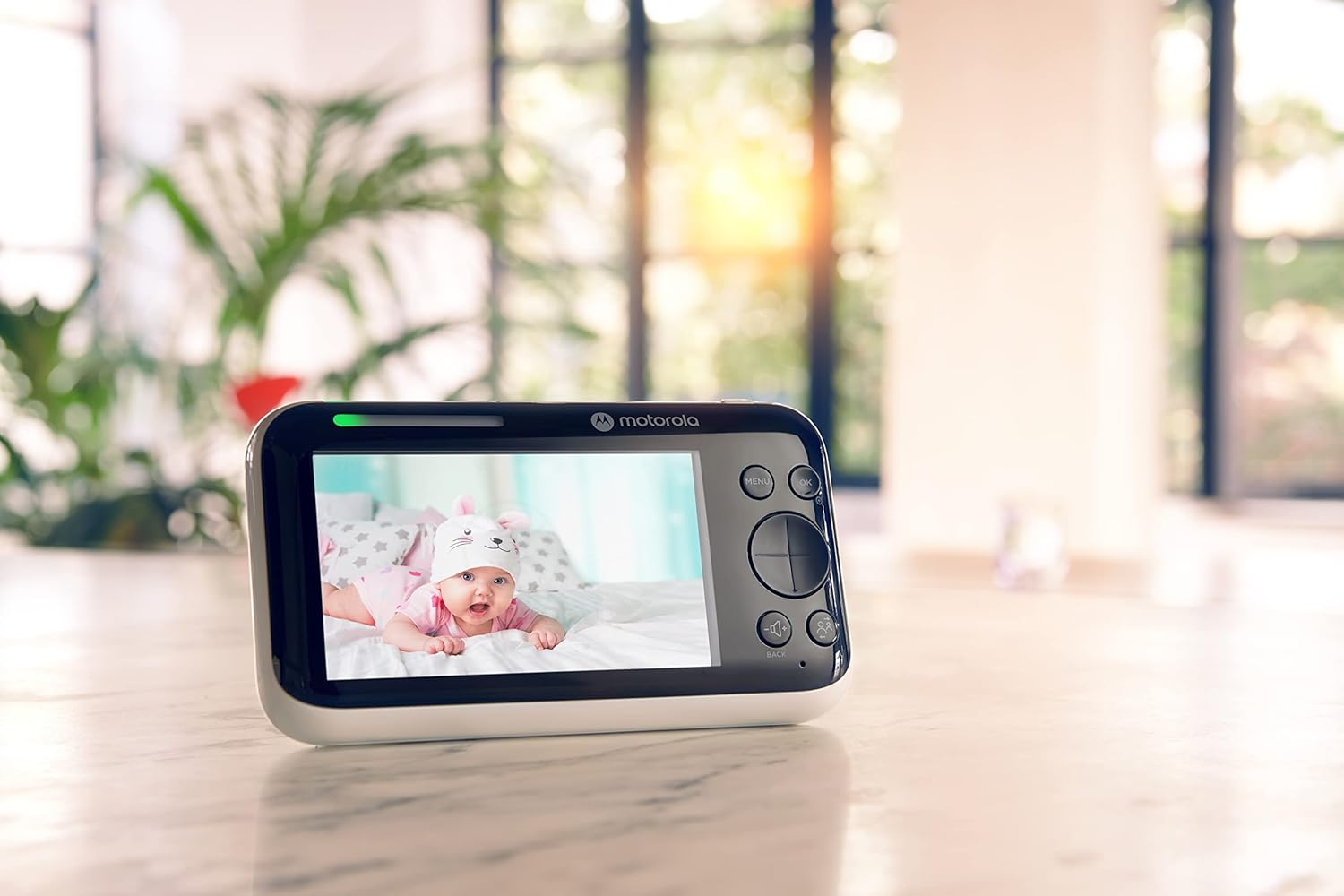 Motorola video baby monitor displaying a baby lying on a soft surface in a well-lit room