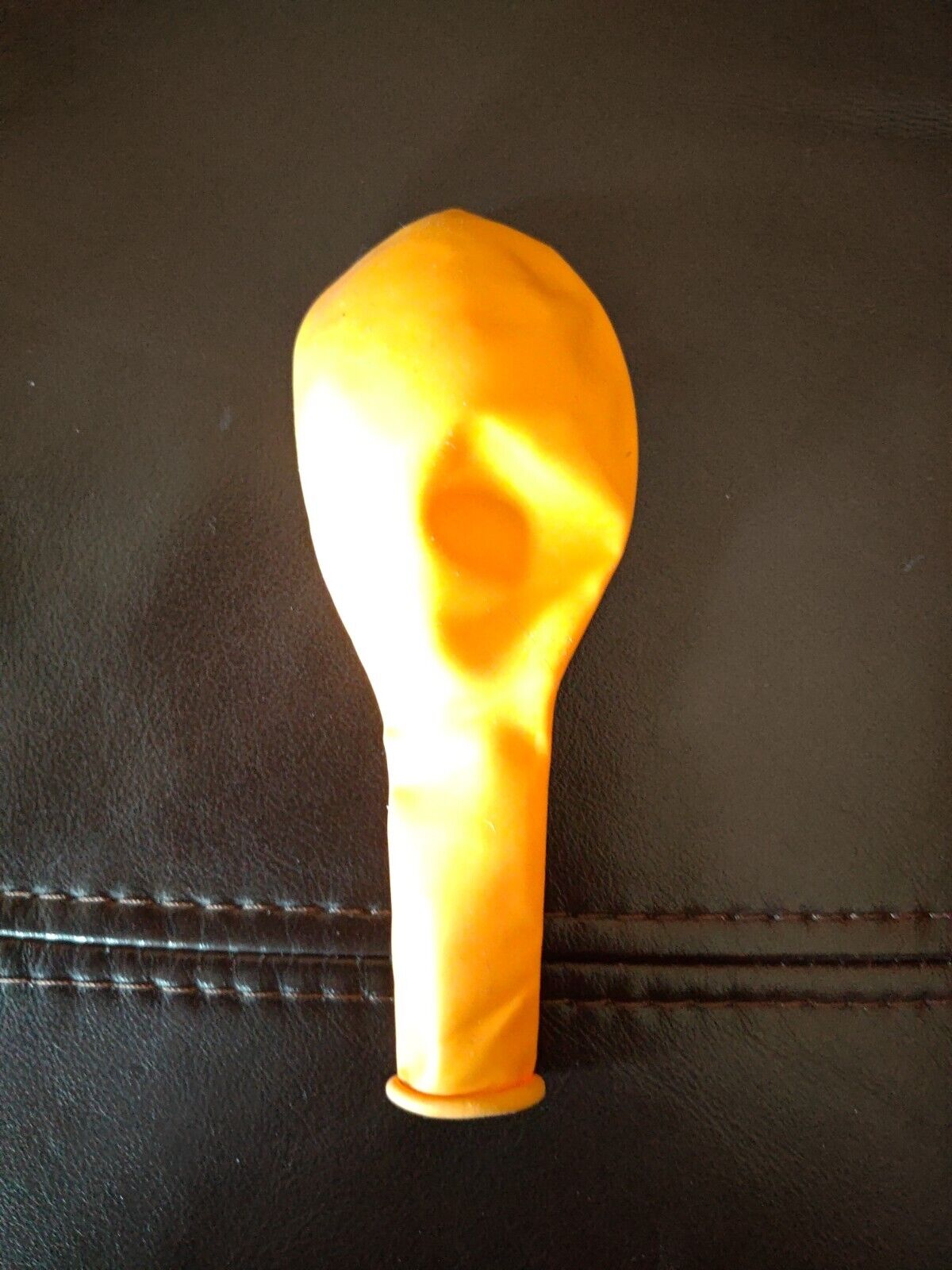 Bethesda yellow deflated balloon on dark brown leather surface homeware accessory