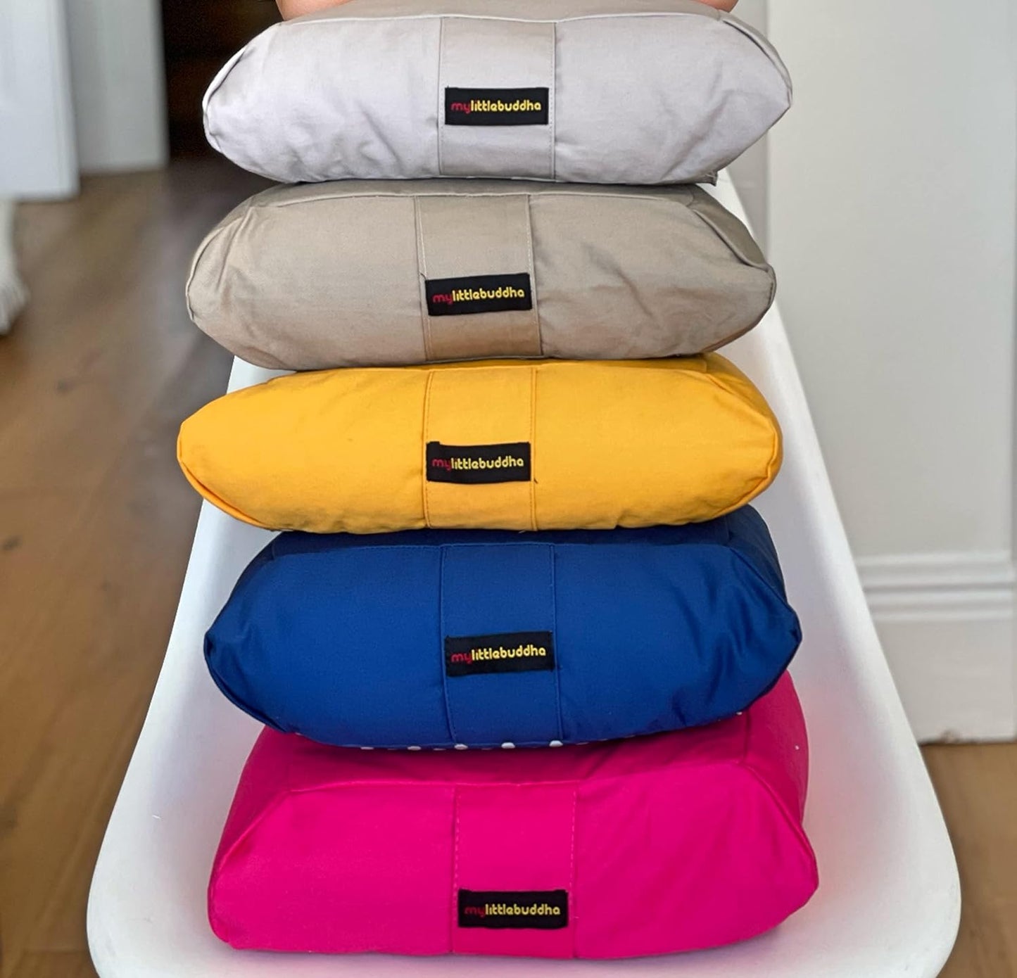 Stack of My Little Buddha organic cotton booster seats in various colours for children's seating