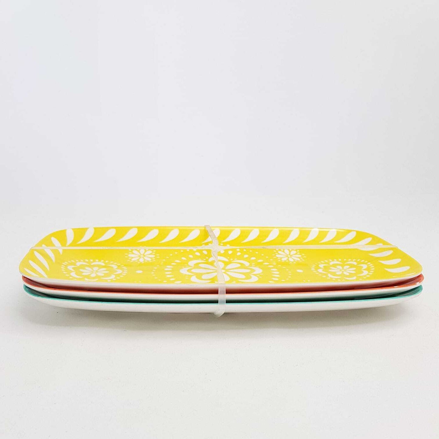 Set of four vibrant serving platters in yellow, green, red, and white from The Trading Warehouse