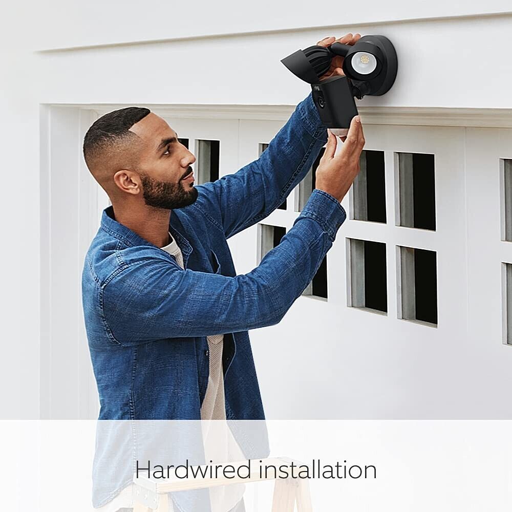 Man installing Ring Floodlight Cam Black on a wall for enhanced outdoor security lighting