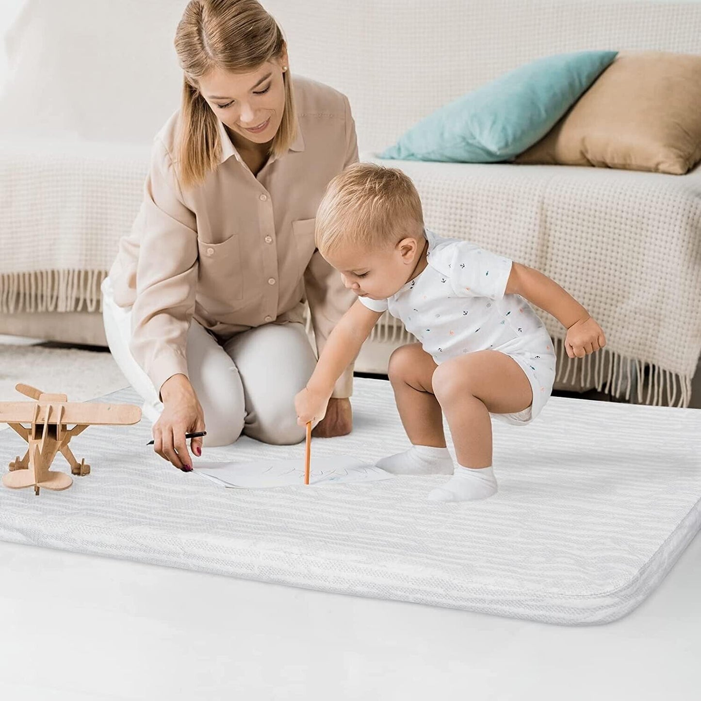 Mother and toddler using the Sprintspirit cot mattress for travel on a soft home floor