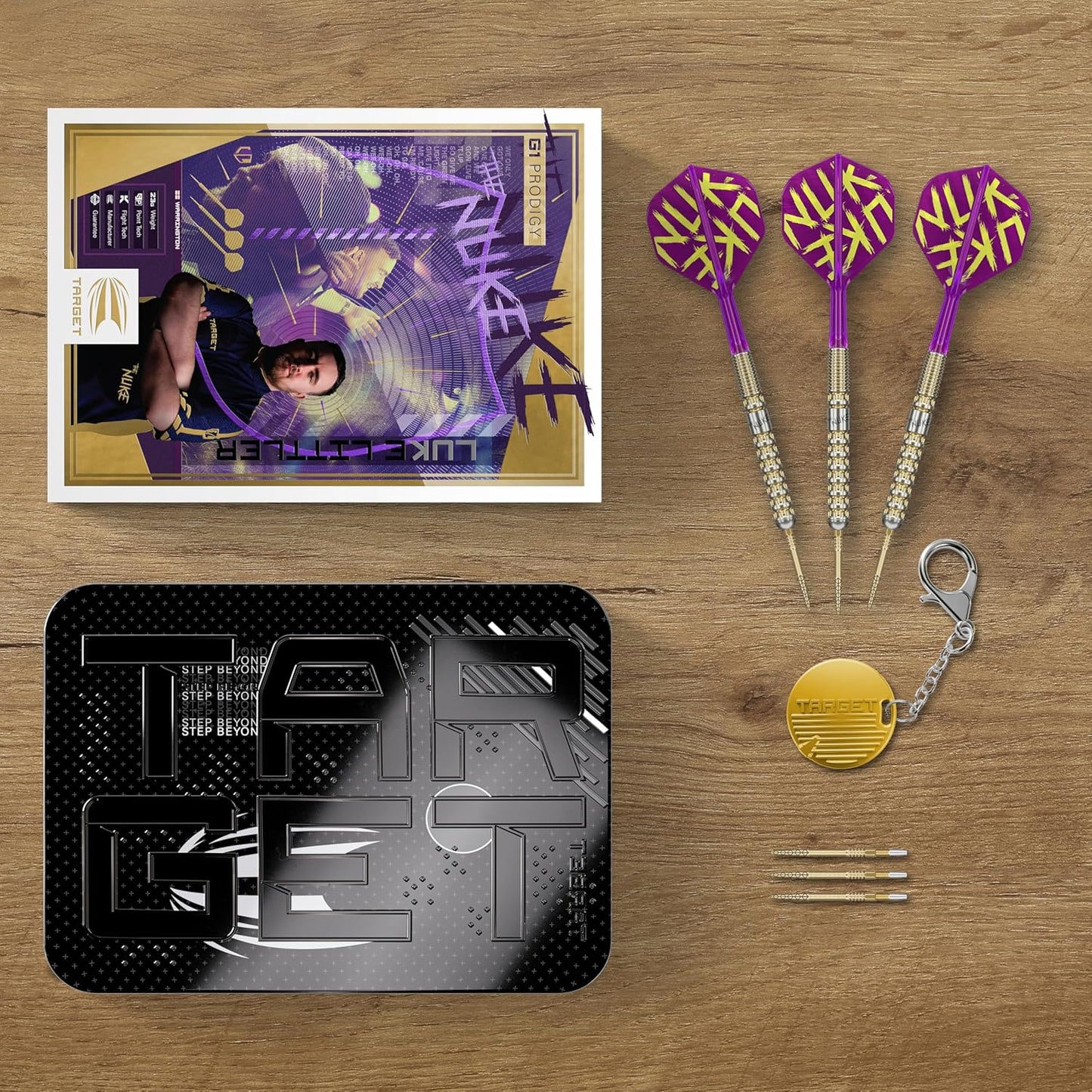 Luke Littler Gen 1 darts set by Target with three purple darts and accessory kit on wooden surface
