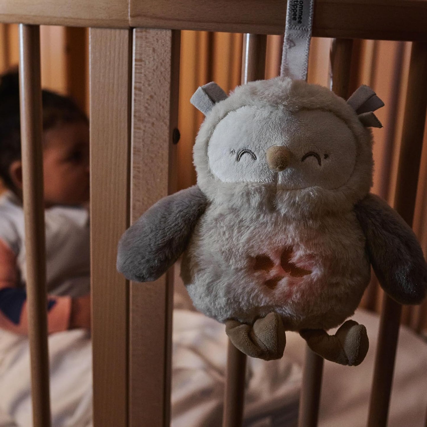 Tomme Tippee Ollie Owl sleep aid hanging in a baby's crib for peaceful sleep support