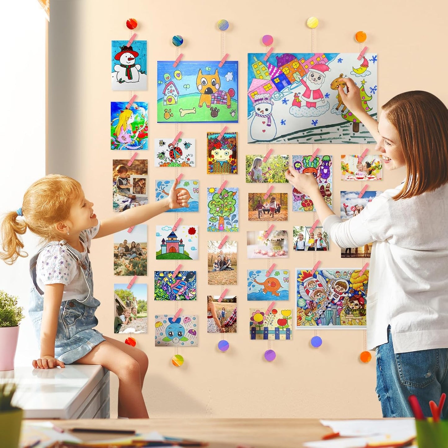 Children decorating with pictures on a wall mounted photo holder pink in a bright living room.