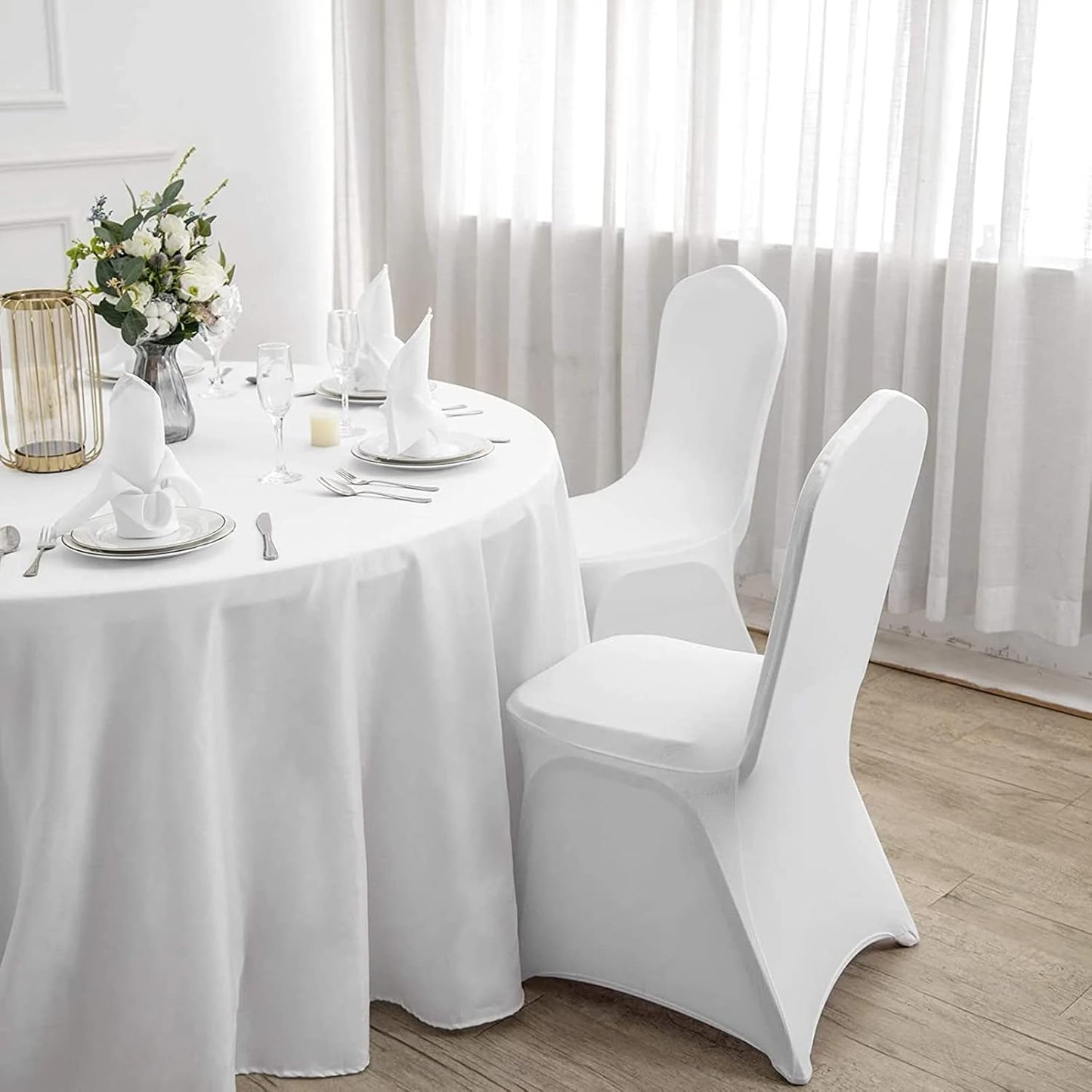 Stylish white polyester stretch chair covers enhancing a dining table setup with elegant decor