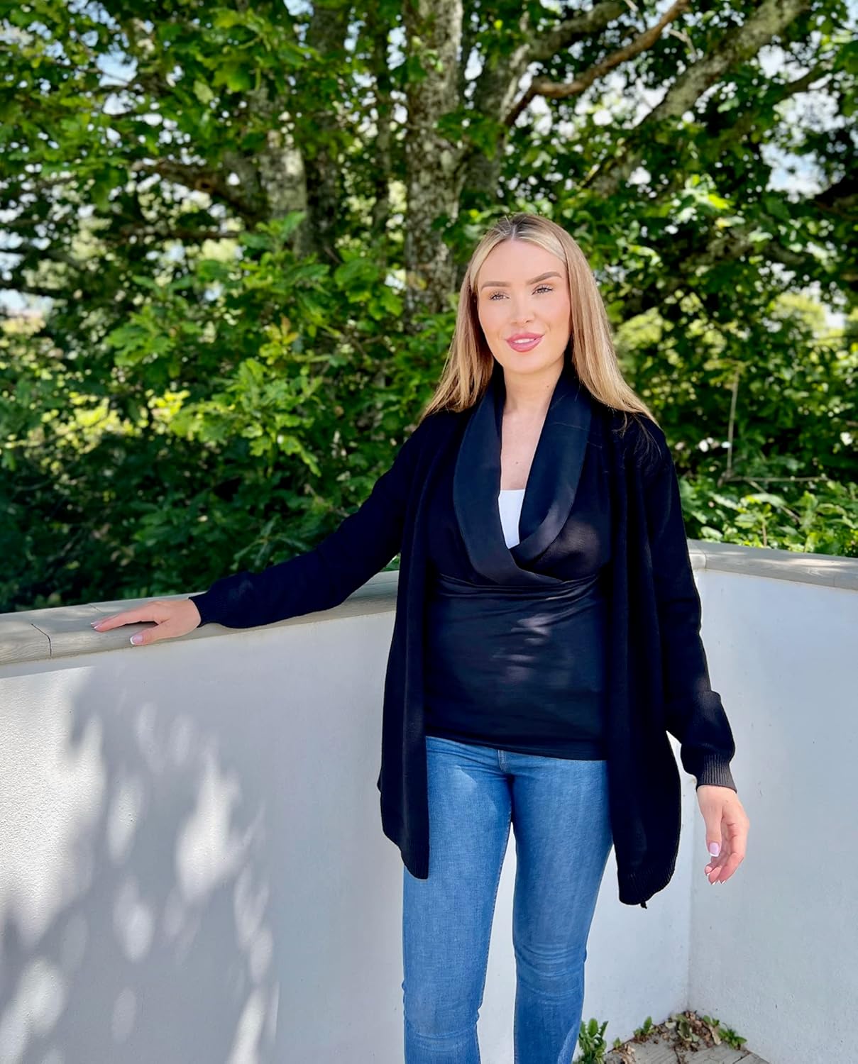 Stylish maternity cardigan with baby carrier in black, perfect for comfortable wear during outings