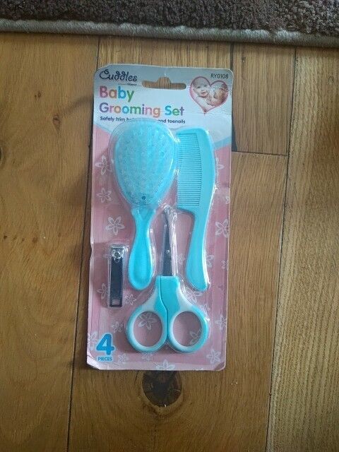 Cuddles baby grooming set featuring a brush, comb, scissors, and nail clipper in blue packaging