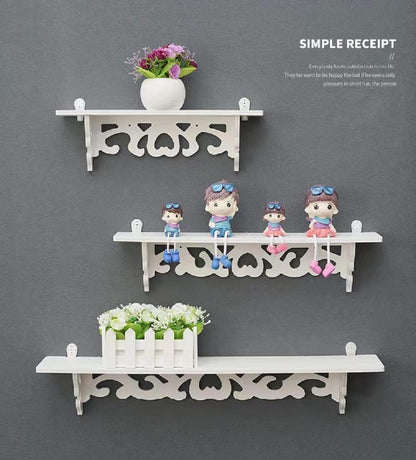 Decorative floating shelves set in white with playful characters and plants for stylish home display