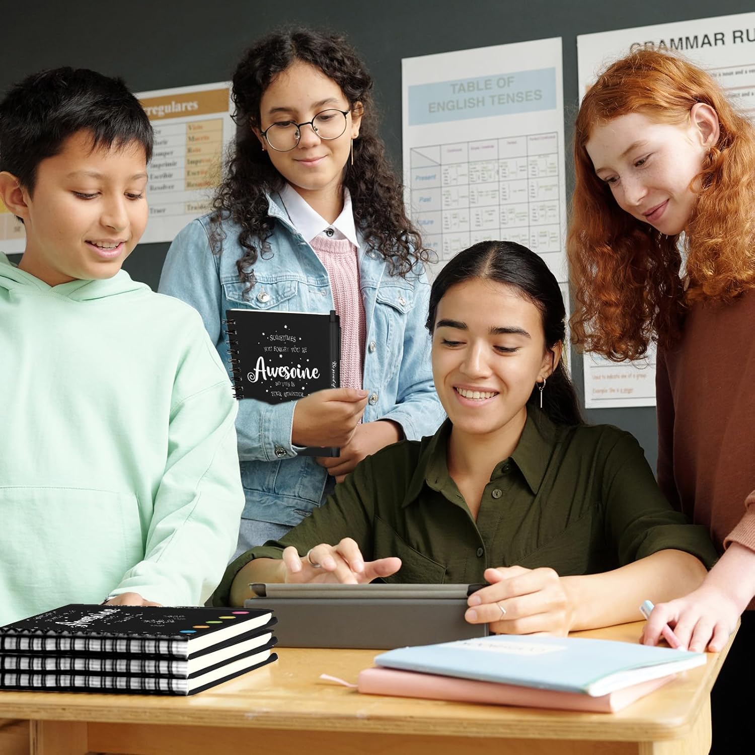 Group of students discussing employee appreciation gifts bulk with a tablet in a classroom setting