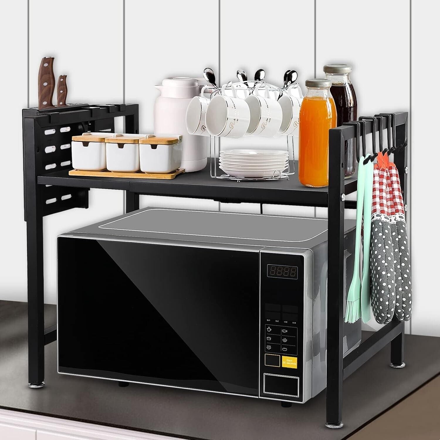 Expandable microwave oven rack on kitchen countertop with storage for utensils and space for a microwave