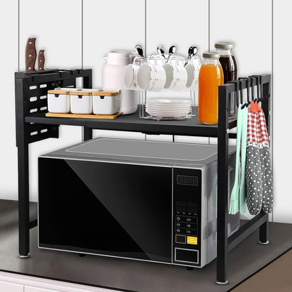 Expandable microwave oven rack on kitchen countertop with storage for utensils and space for a microwave