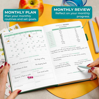 Clever Fox fitness and food journal open on a table with notes for monthly planning and review