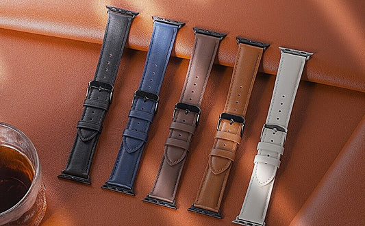 Various genuine black leather apple watch strap options displayed on a smooth surface