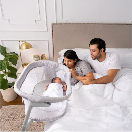 Halo baby bassinet sleeper beside parents on a bed, creating a safe sleep space for infants