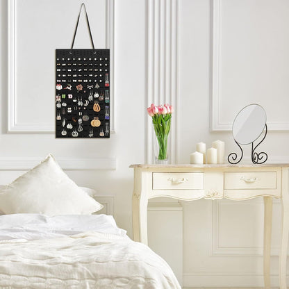 Elegant hanging earrings holder in black displayed in a stylish bedroom interior