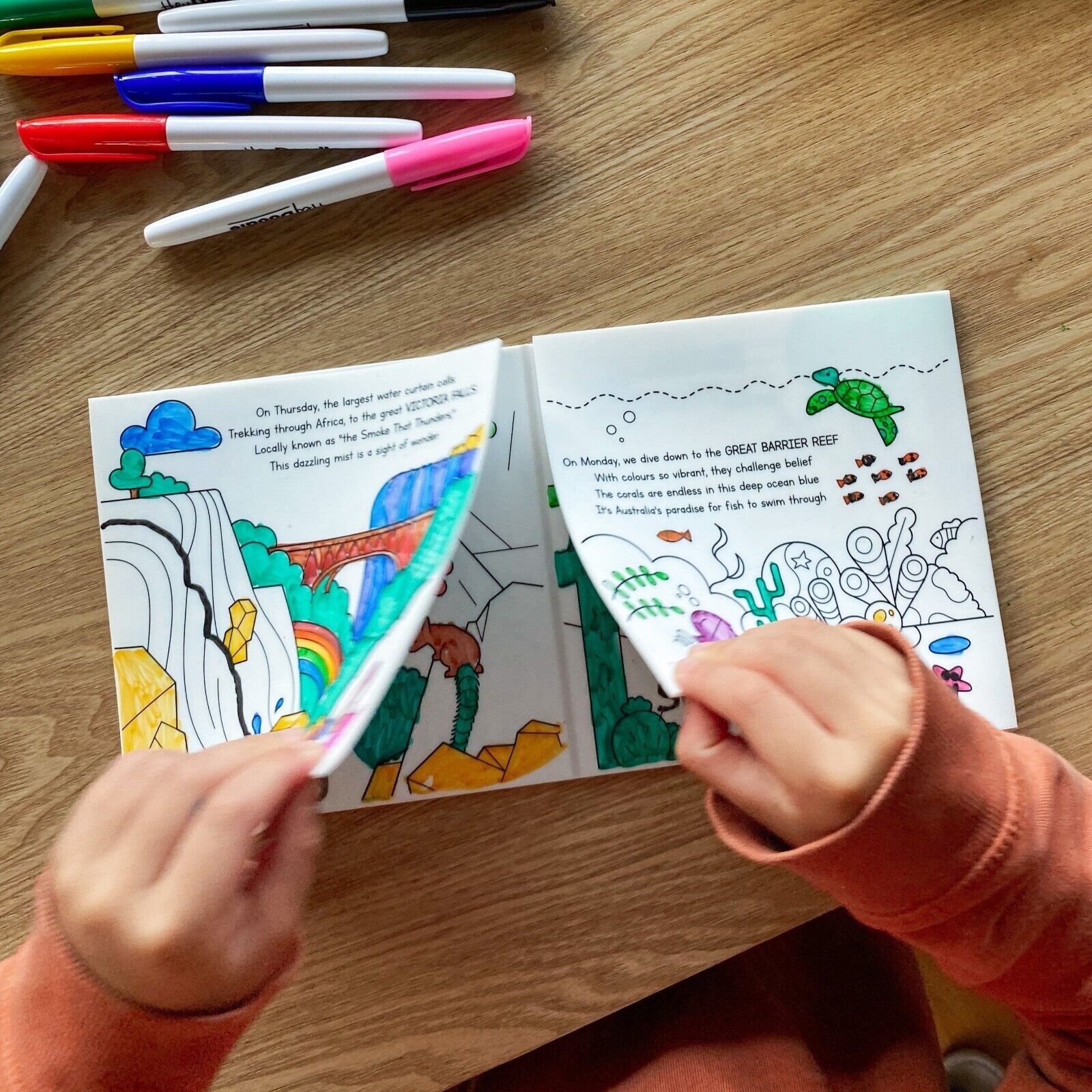 Child engaged with HeyDoodle Tales Natural Wonders activity book, exploring colourful illustrations