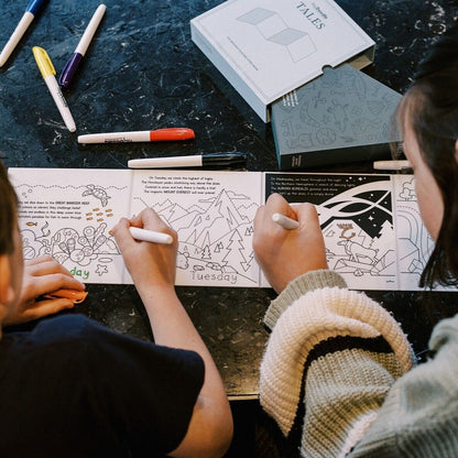 Children using markers to colour pages in the HeyDoodle Tales Natural Wonders activity book
