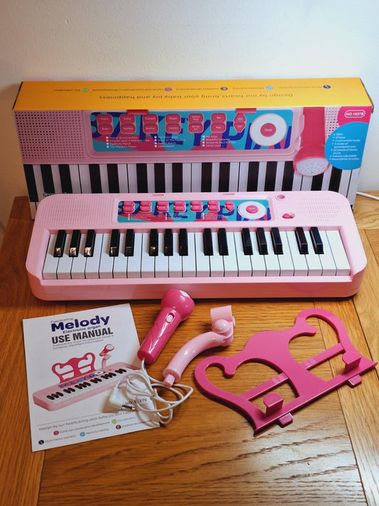 Fascinating kids piano keyboard with microphone in pink, complete with stand and user manual