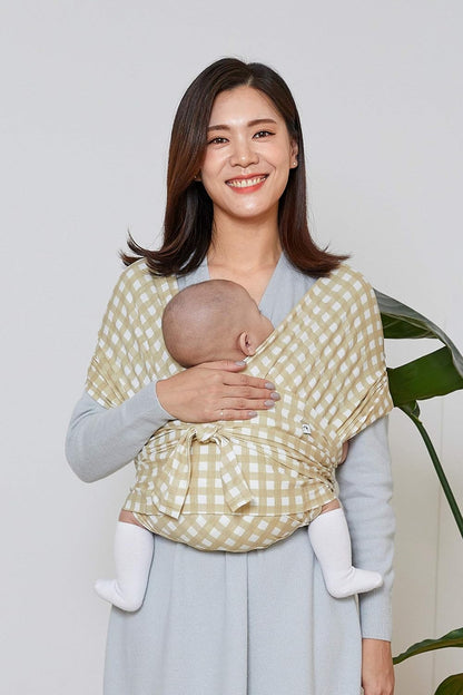 Konny lightweight infant carrier for mums in beige gingham, comfortably holding a baby close