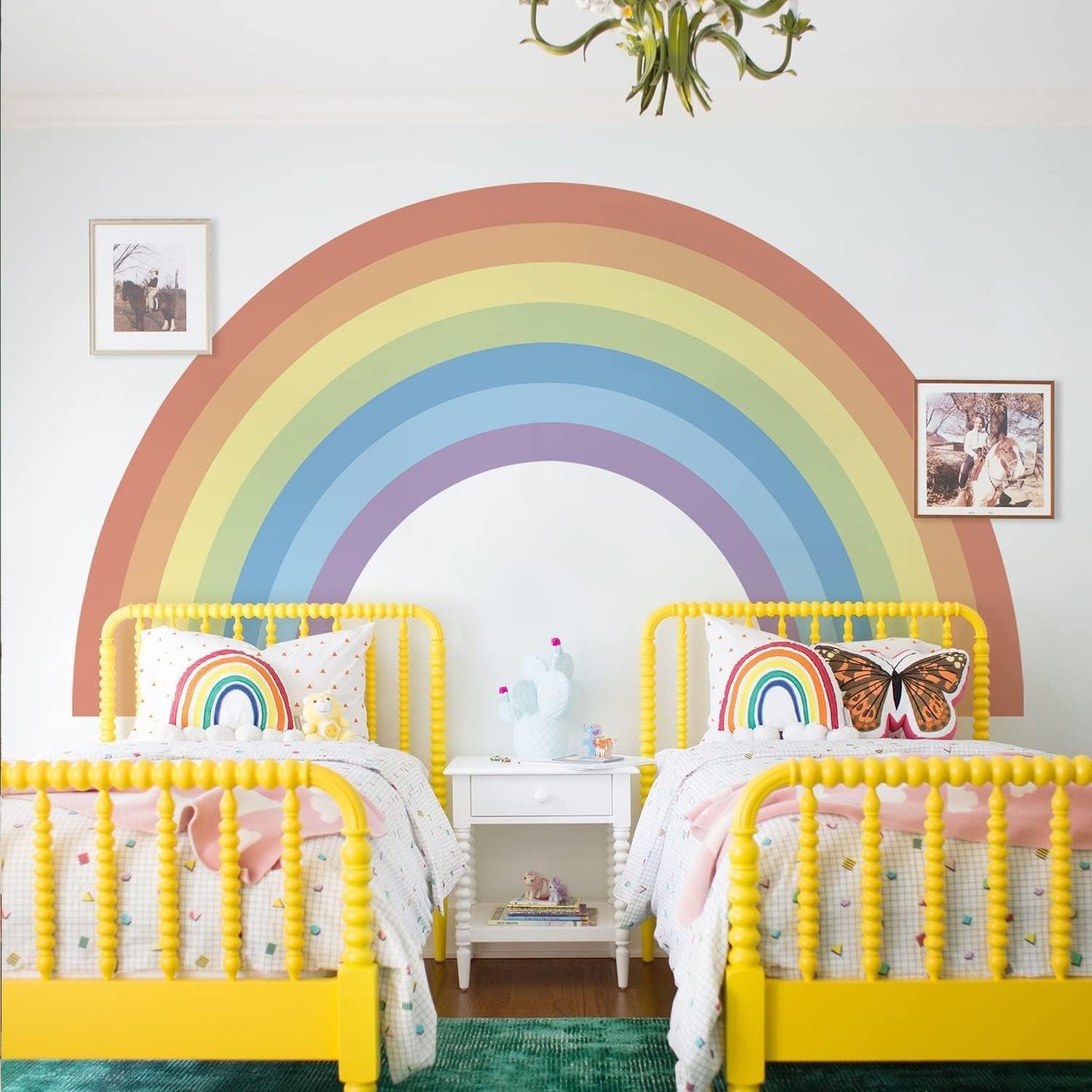 Large pastel rainbow wall stickers creating a cheerful bedroom decor for children with yellow beds