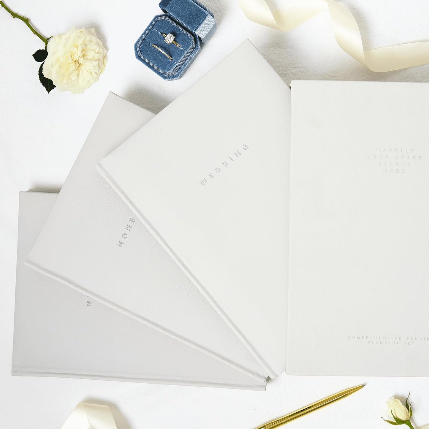 Luxury wedding planner set by Scribble & Dot featuring elegant covers and gold accents