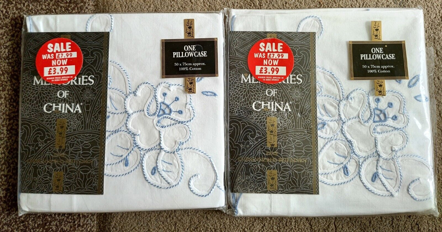 Memories of China pillowcases featuring floral embroidery in blue on soft white fabric