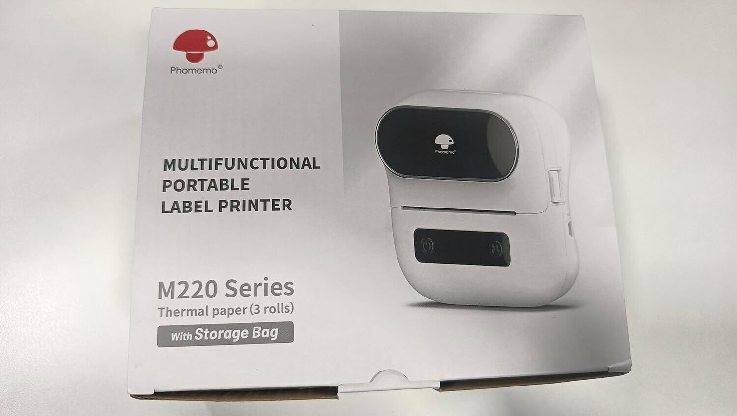 Phomemo M220 portable barcode printer in box with storage bag and thermal paper rolls included