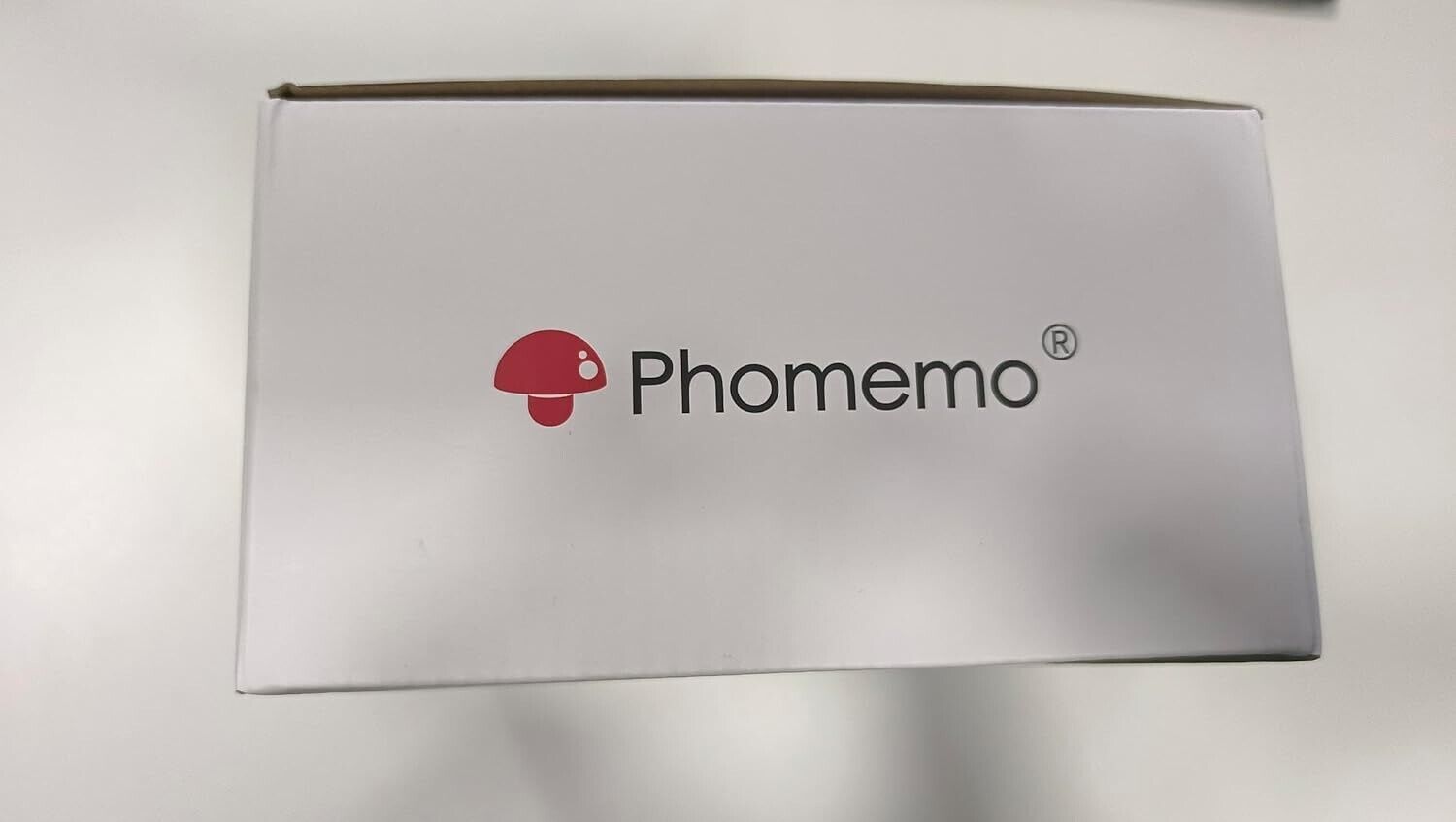 Phomemo M220 portable barcode printer packaging featuring the Phomemo logo on a white box