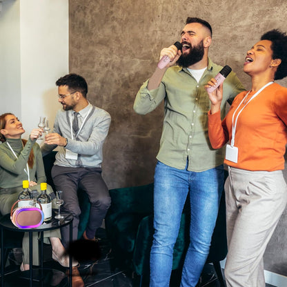 Group of friends enjoying a party with a pink Bluetooth karaoke machine, singing and celebrating together