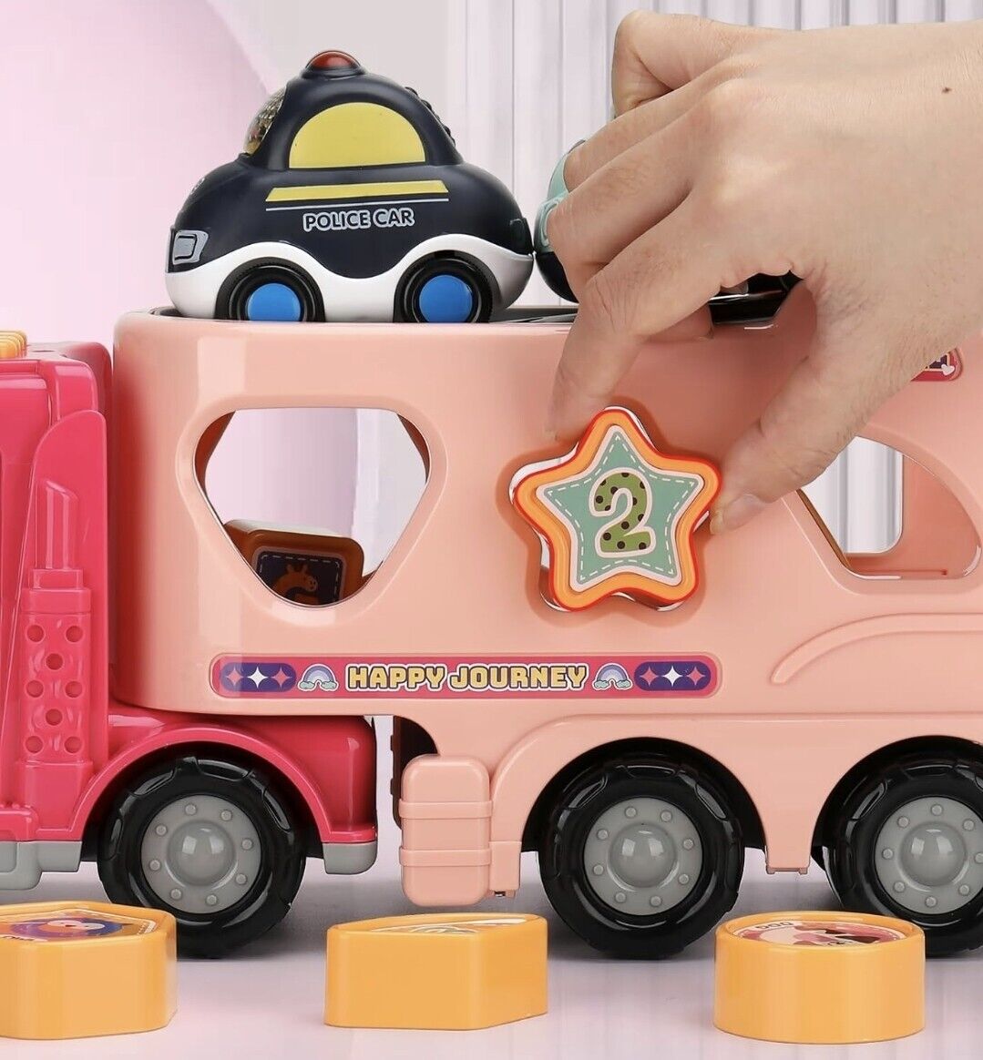 Child playing with a pink truck toy for girls, featuring compartments for toy cars and colourful shapes