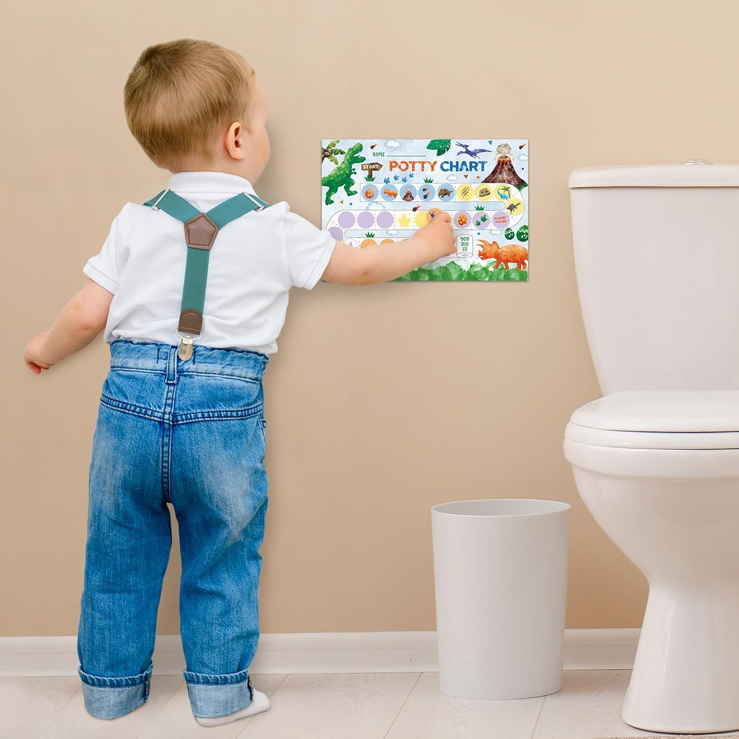 Toddler using potty training chart for toddlers on a wall next to a toilet for effective potty training