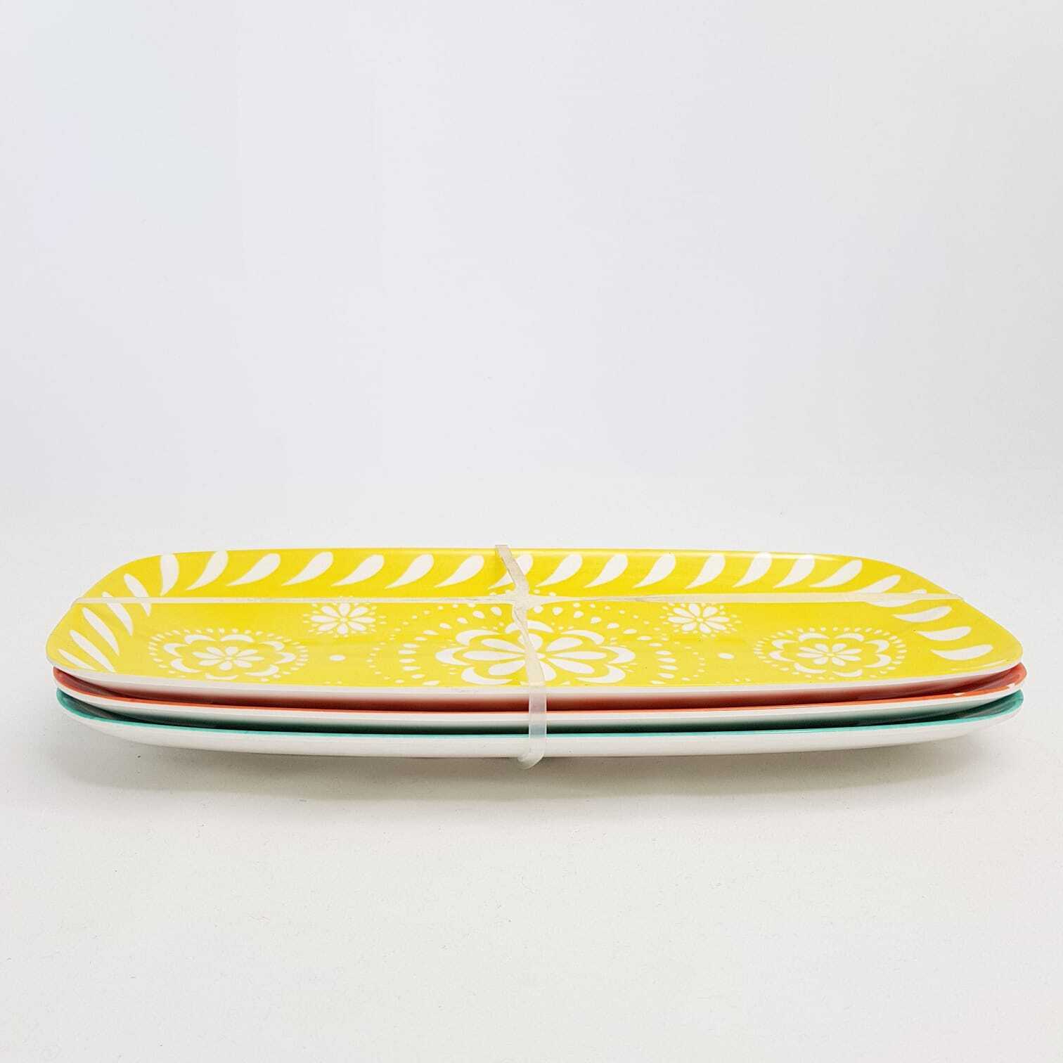 Set of four vibrant serving platters in yellow, green, red, and white from The Trading Warehouse