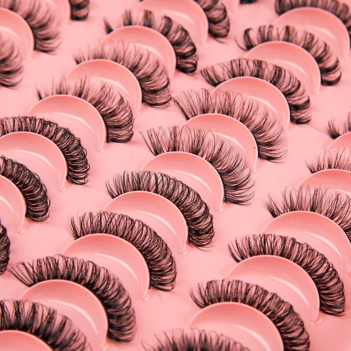 Variety of Russian strip lashes displayed on a pink background for dramatic eye enhancement