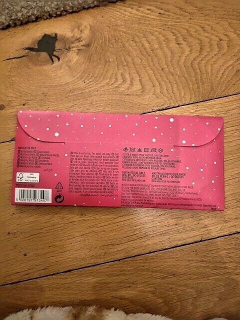 The Body Shop beauty sleeping mask packaging in pink with white spots, featuring product details and instructions
