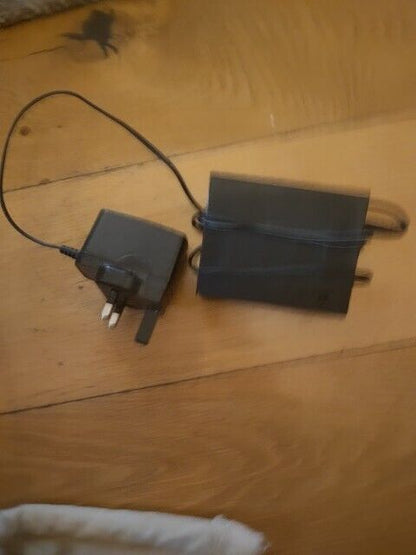 TP-LINK 5 port gigabit switch with power adapter on a wooden surface for network connectivity