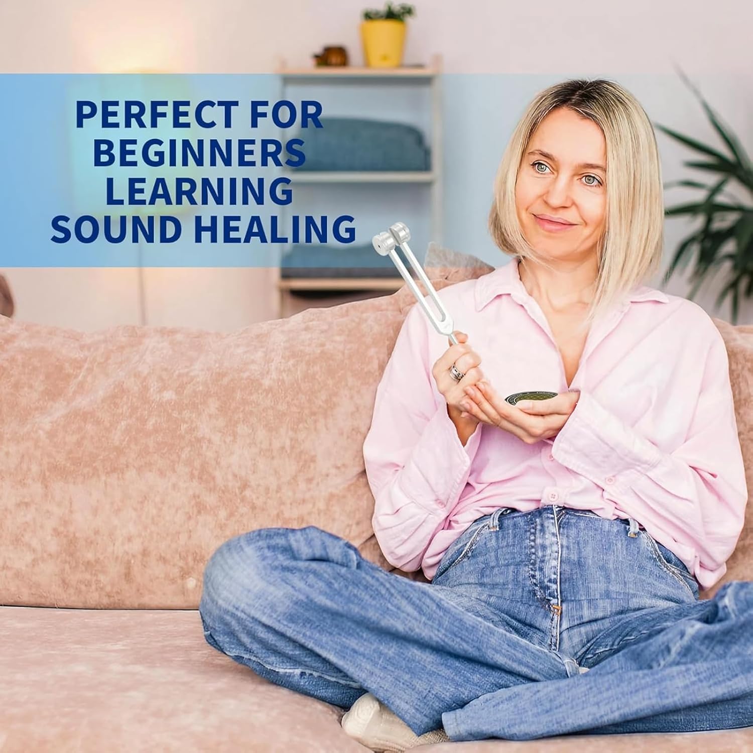 Woman sitting on a sofa holding tuning forks for healing, ideal for beginners in sound healing
